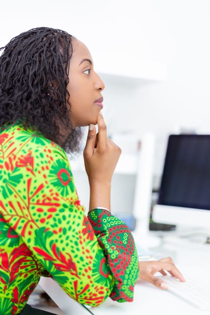 Jeune femme concentrée devant un ordinateur dans un bureau lumineux